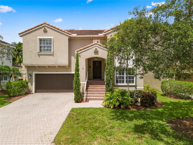 mediterranean / spanish home featuring a front lawn and a garage