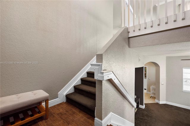 stairs featuring hardwood / wood-style floors and a towering ceiling