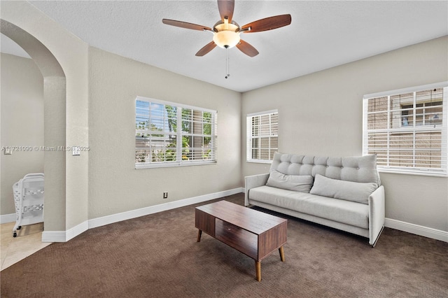 carpeted living room with ceiling fan