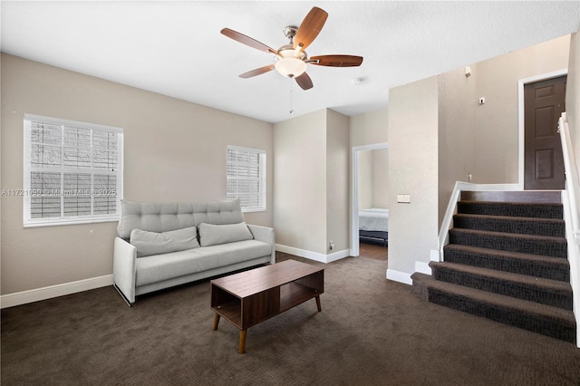 living room featuring dark colored carpet and ceiling fan