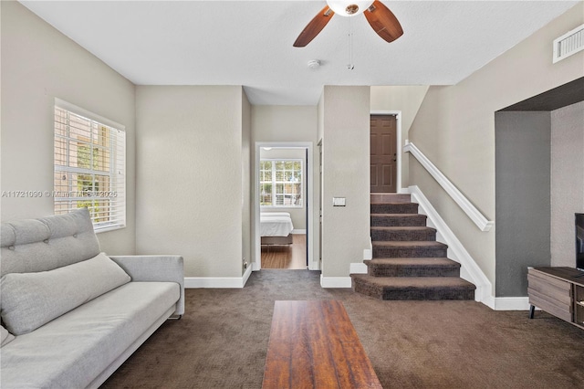 living room with ceiling fan and dark carpet