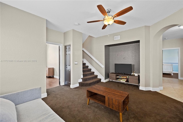 carpeted living room with ceiling fan