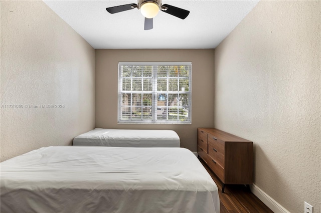 bedroom with ceiling fan and dark hardwood / wood-style flooring