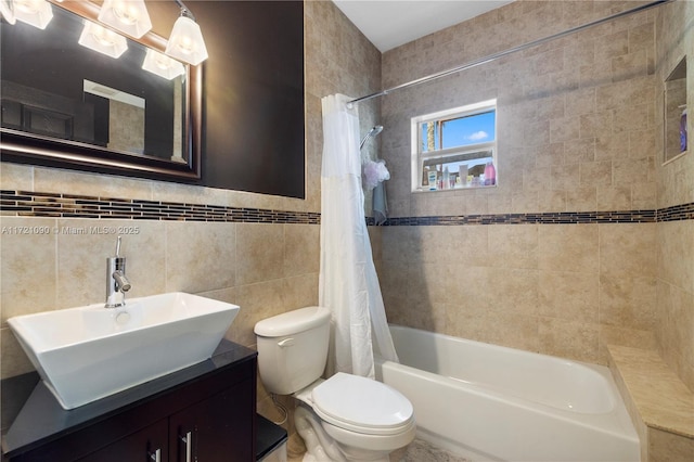 full bathroom with shower / tub combo, vanity, toilet, and tile walls