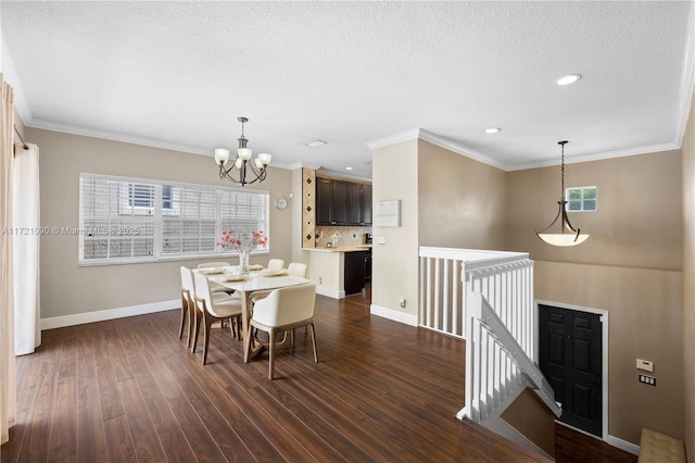 dining room featuring crown molding, dark hardwood / wood-style flooring, a textured ceiling, and an inviting chandelier