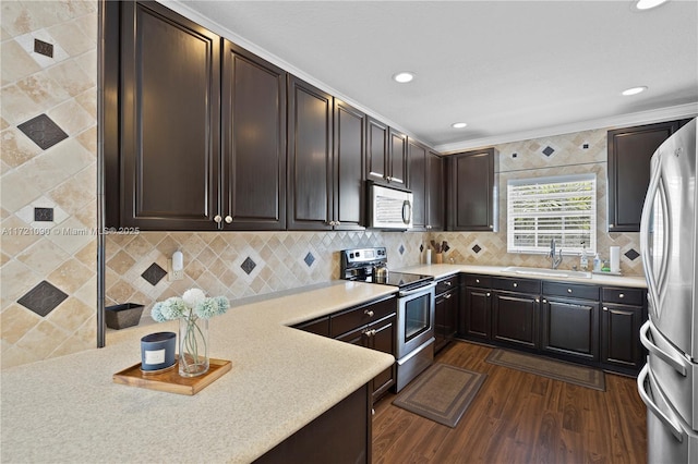 kitchen featuring dark wood-type flooring, sink, ornamental molding, dark brown cabinetry, and stainless steel appliances