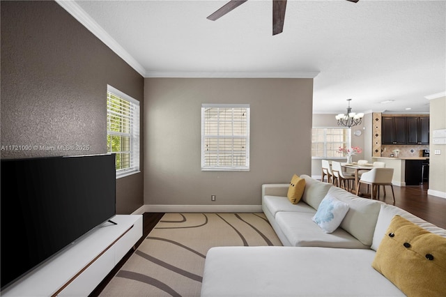 living room with ceiling fan with notable chandelier, dark hardwood / wood-style floors, and ornamental molding