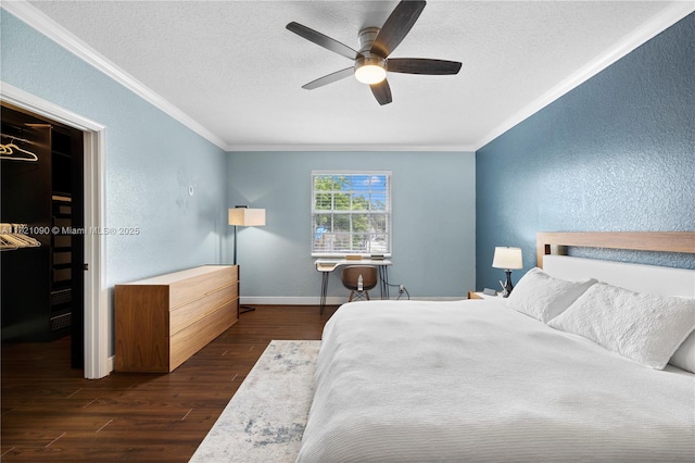 bedroom with ceiling fan, dark hardwood / wood-style flooring, ornamental molding, and a textured ceiling