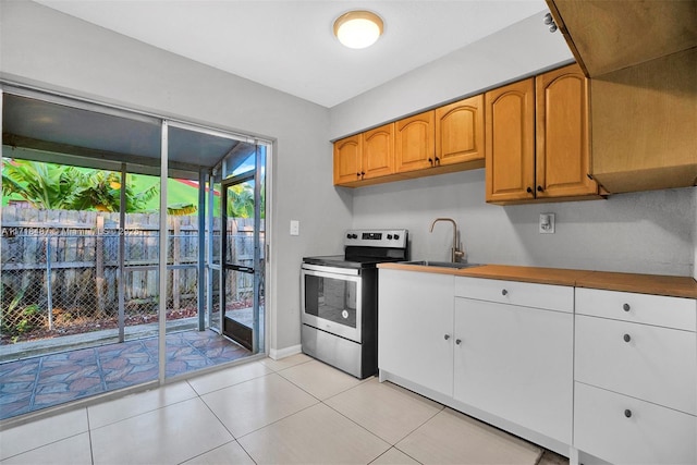 kitchen with stainless steel range with electric stovetop, light tile patterned flooring, and sink