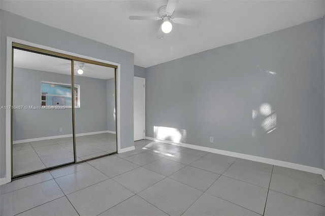 unfurnished bedroom featuring ceiling fan, a closet, and light tile patterned floors