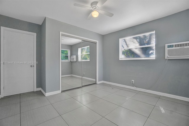 unfurnished bedroom with ceiling fan, a closet, light tile patterned floors, and a wall mounted air conditioner