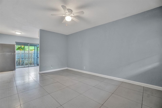 spare room with ceiling fan and light tile patterned floors