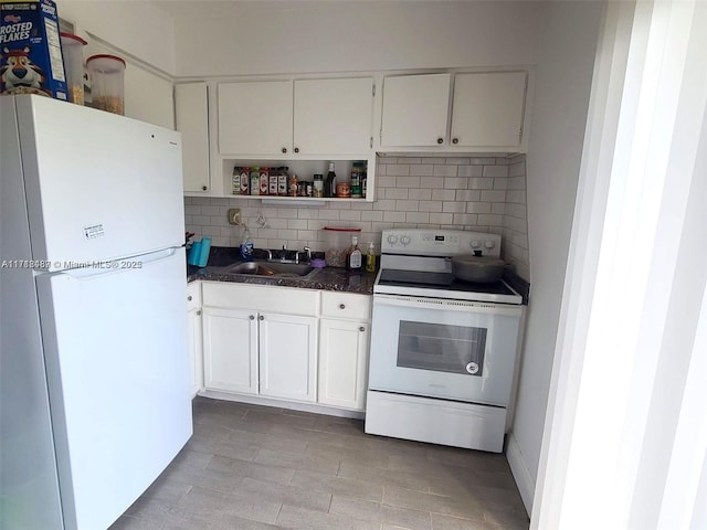 kitchen featuring white appliances, backsplash, white cabinetry, and sink