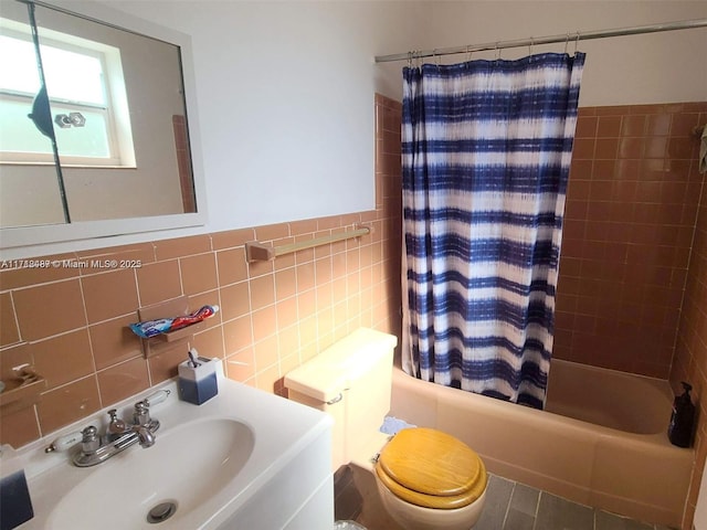 full bathroom featuring tile patterned floors, shower / tub combo with curtain, sink, tile walls, and toilet