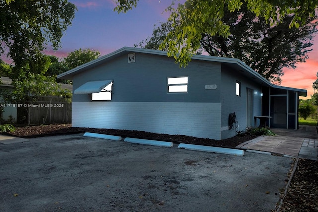 property exterior at dusk with a patio