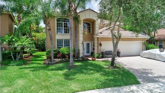 mediterranean / spanish house with a garage and a front lawn