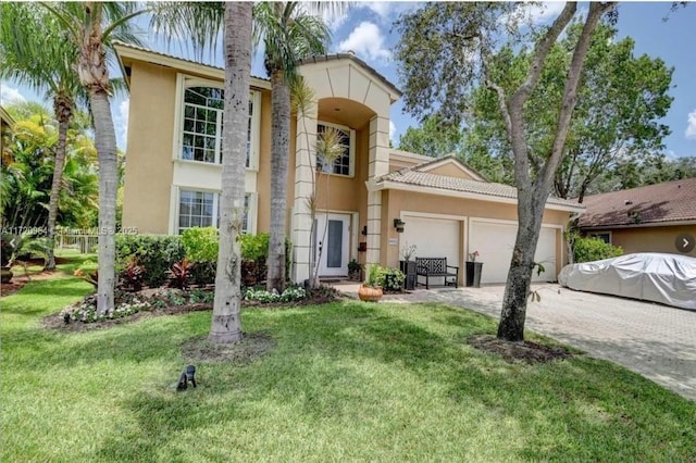 mediterranean / spanish house with a front lawn and a garage