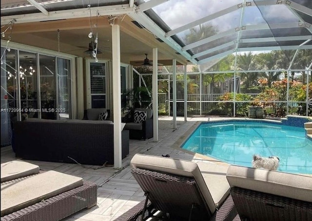 view of pool featuring a patio, outdoor lounge area, and glass enclosure