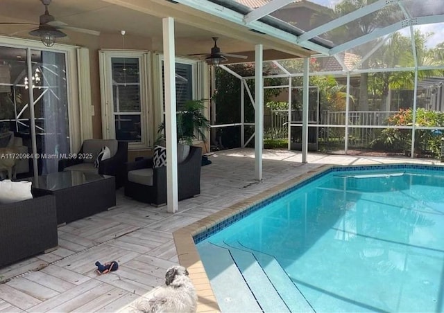 view of swimming pool featuring a patio area, an outdoor hangout area, and glass enclosure