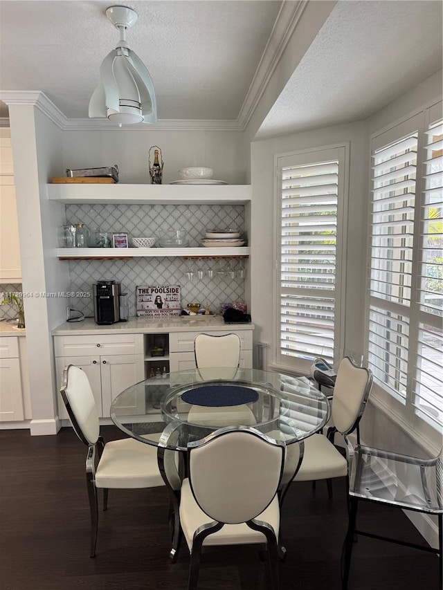 dining space with crown molding, dark hardwood / wood-style floors, and a textured ceiling