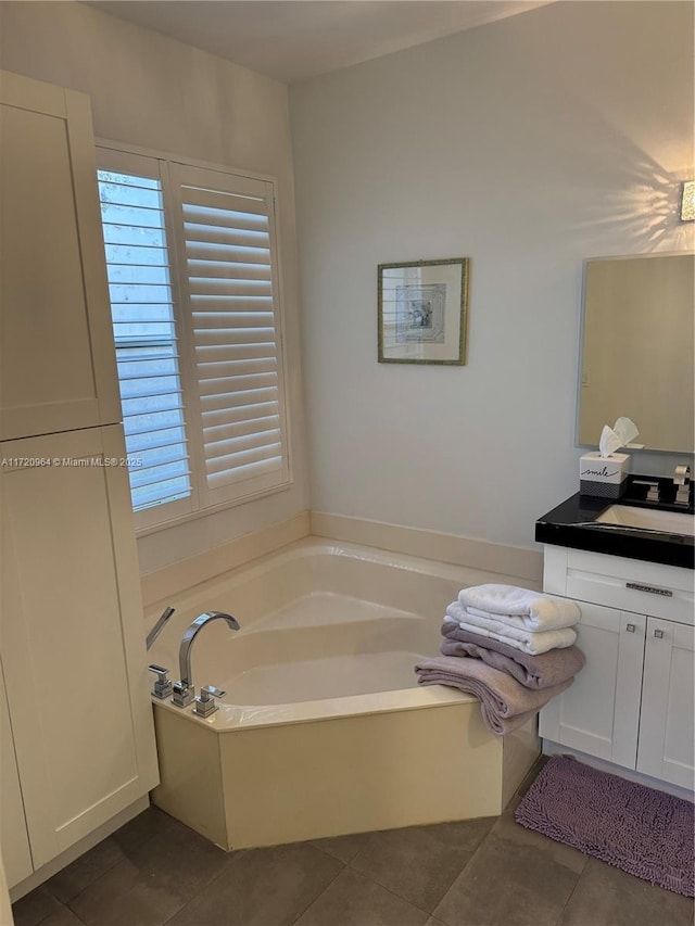 bathroom with vanity, a washtub, and tile patterned floors