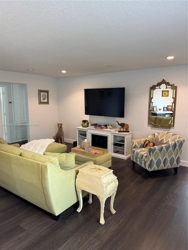 living room with dark wood-type flooring and a textured ceiling