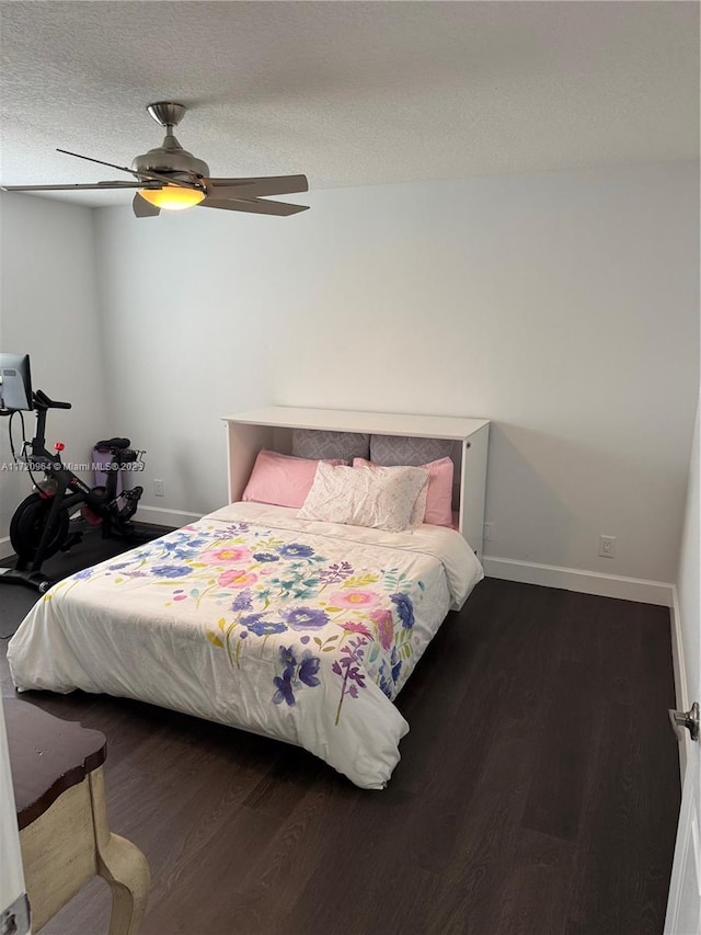 bedroom with dark wood-type flooring, ceiling fan, and a textured ceiling