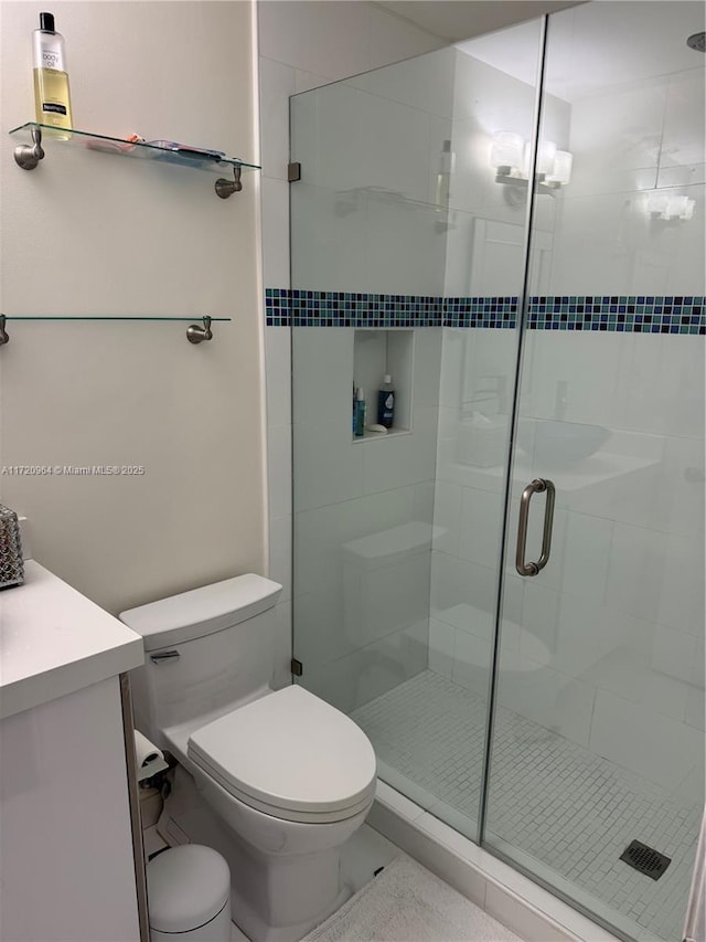 bathroom with walk in shower, vanity, and toilet