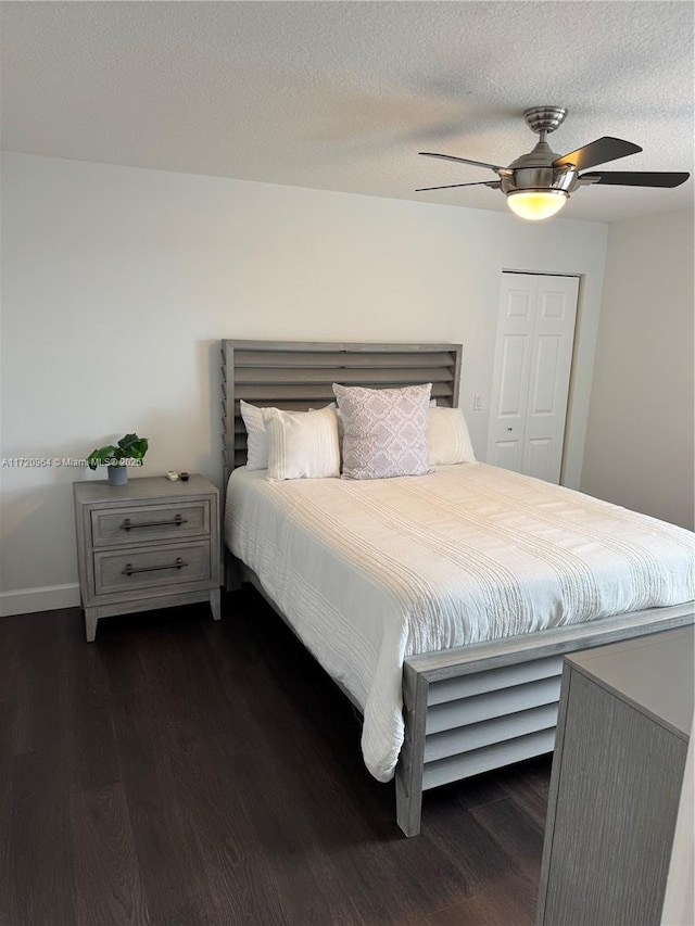 bedroom with a textured ceiling, dark wood-type flooring, a closet, and ceiling fan