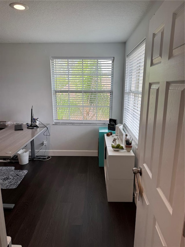 home office with dark wood-type flooring and a textured ceiling