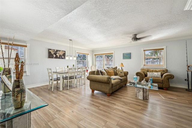 living room with ceiling fan, wood-type flooring, and ornamental molding