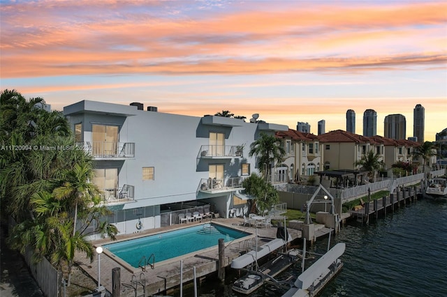 exterior space with a dock, a water view, and a patio