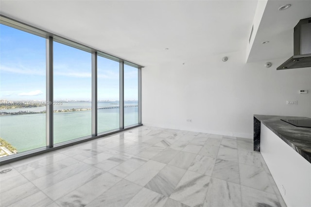 unfurnished living room featuring expansive windows and a water view