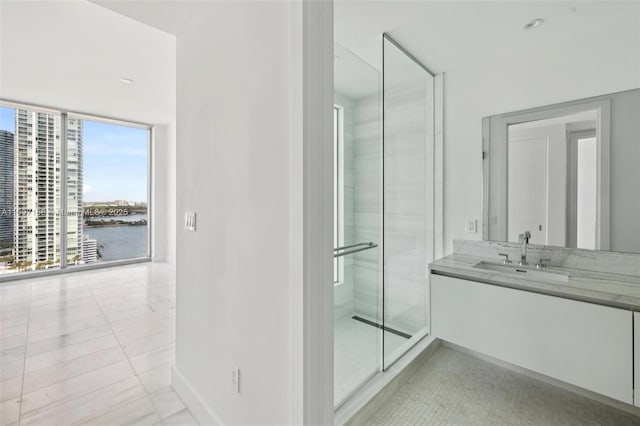 bathroom with walk in shower, tile patterned flooring, expansive windows, a water view, and vanity