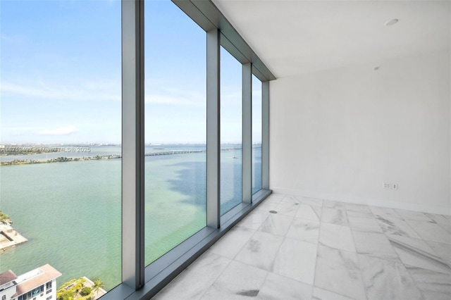 empty room with a water view, a wall of windows, and a wealth of natural light