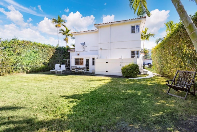 rear view of house featuring a lawn