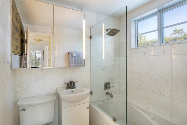 full bathroom with tasteful backsplash, vanity, tiled shower / bath combo, tile walls, and toilet