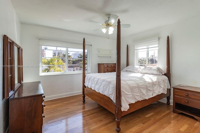 bedroom featuring multiple windows, ceiling fan, and hardwood / wood-style flooring