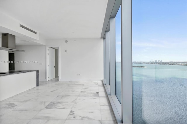 corridor featuring a water view and expansive windows