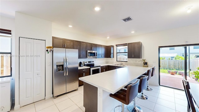 kitchen featuring a wealth of natural light, sink, stainless steel appliances, and a breakfast bar area