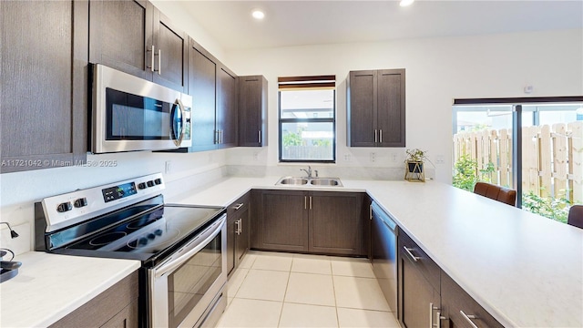 kitchen with a healthy amount of sunlight, light tile patterned floors, sink, and appliances with stainless steel finishes