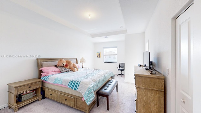 carpeted bedroom featuring a tray ceiling