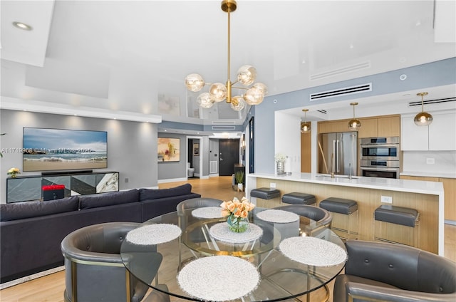 dining area with an inviting chandelier and light hardwood / wood-style flooring