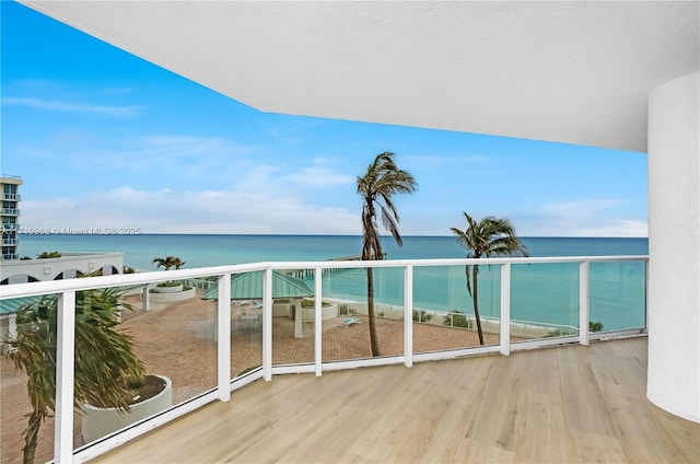 balcony featuring a beach view and a water view