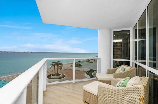 balcony featuring a water view and a view of the beach