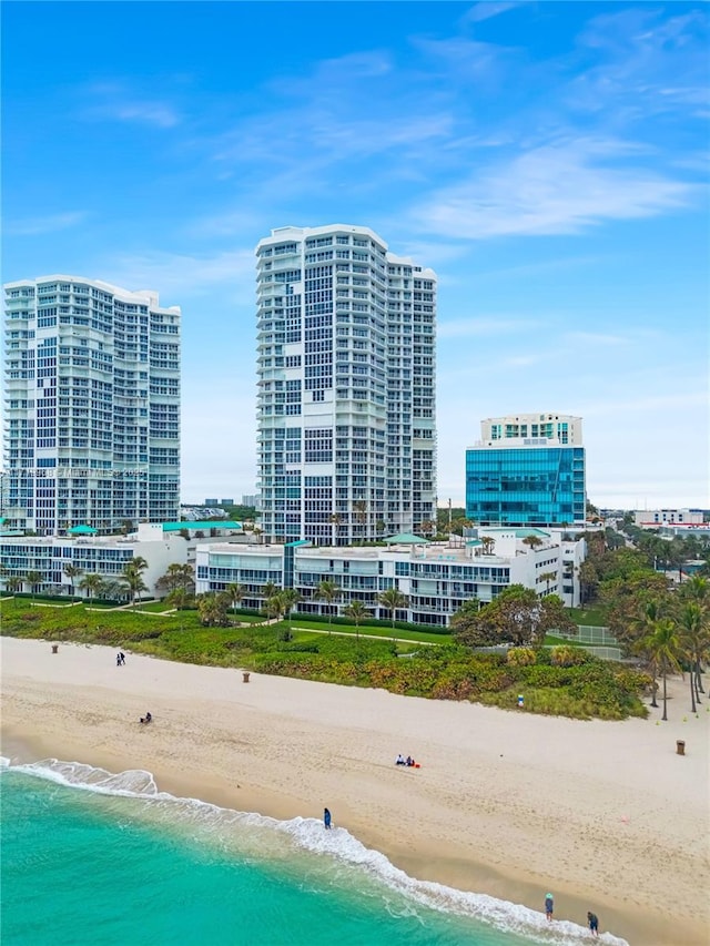 birds eye view of property with a water view and a beach view