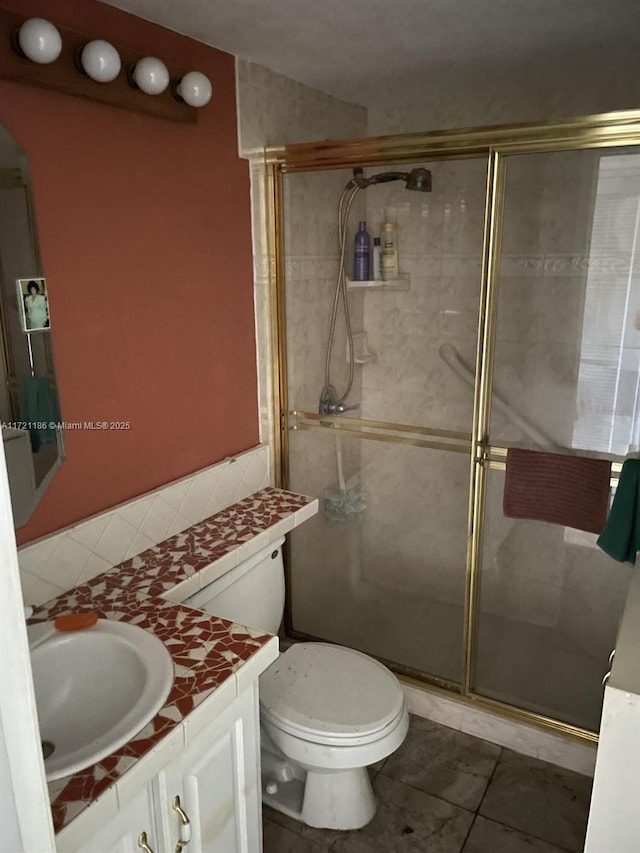 bathroom with a shower with door, vanity, and toilet