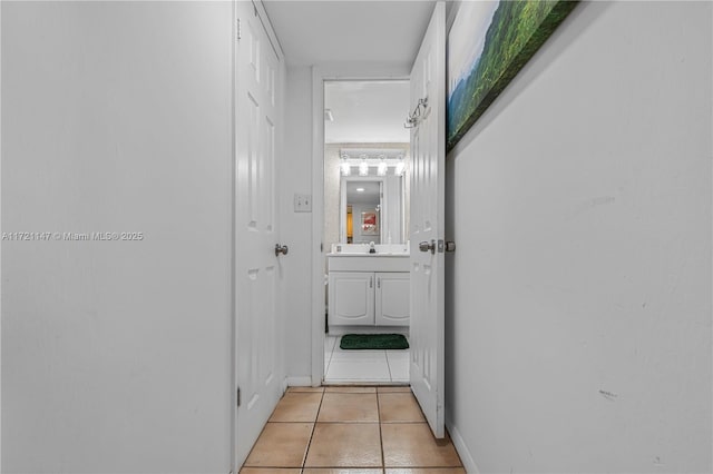 corridor with sink and light tile patterned floors