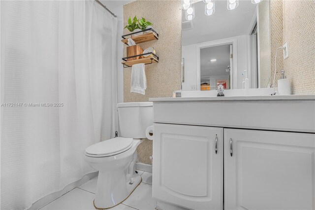 bathroom with toilet, vanity, and tile patterned floors