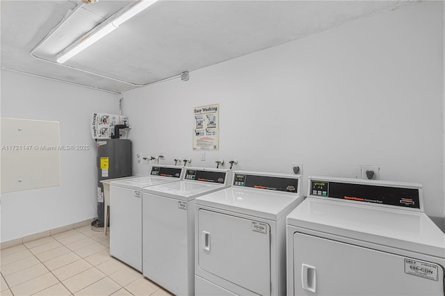 shared laundry area with light tile patterned floors, washing machine and clothes dryer, and electric water heater